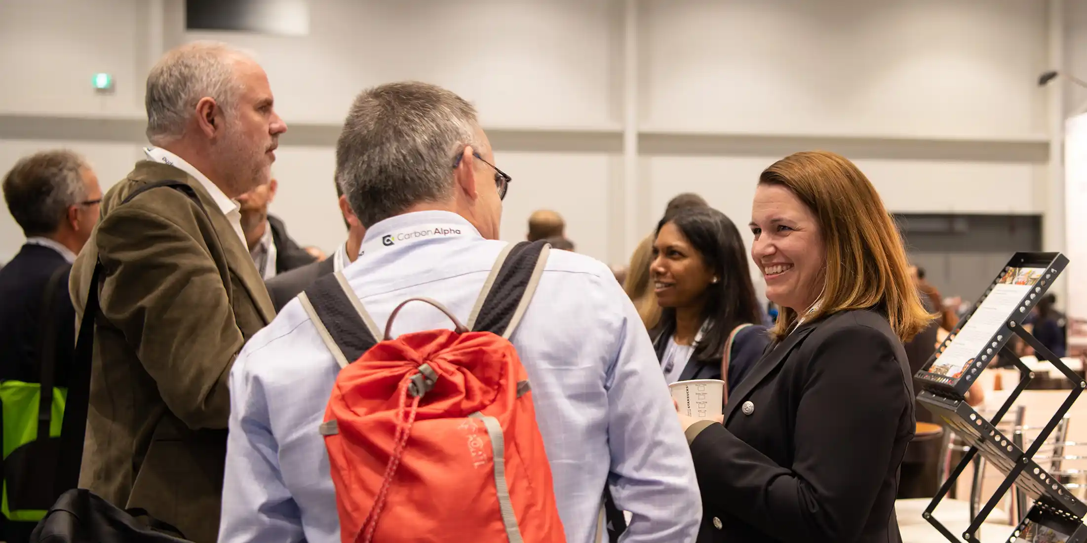 Exhibit at GHGT-18 - Smiling woman talking at GHGT-17 Conference Exhibition